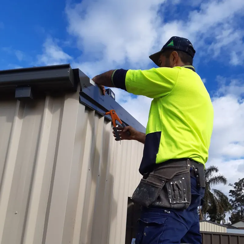 Tradesman installing new guttering